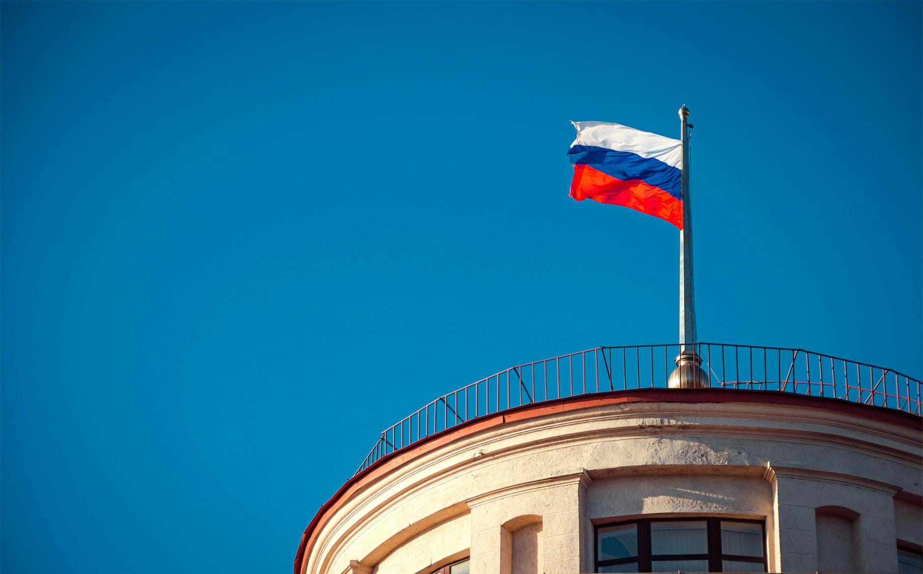 photograph of a russia flag under a blue sky